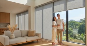 Modern Asian couple admiring premium roller blinds by Ministry of Blind in a Singapore HDB living room